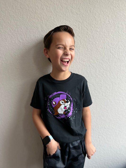 A child wearing a black shirt with a purple circle in the middle with an image of a beaver