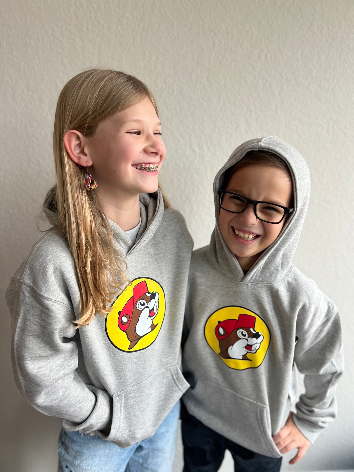 A boy and a girl laughing wearing Grey Bucee's sweatshirts