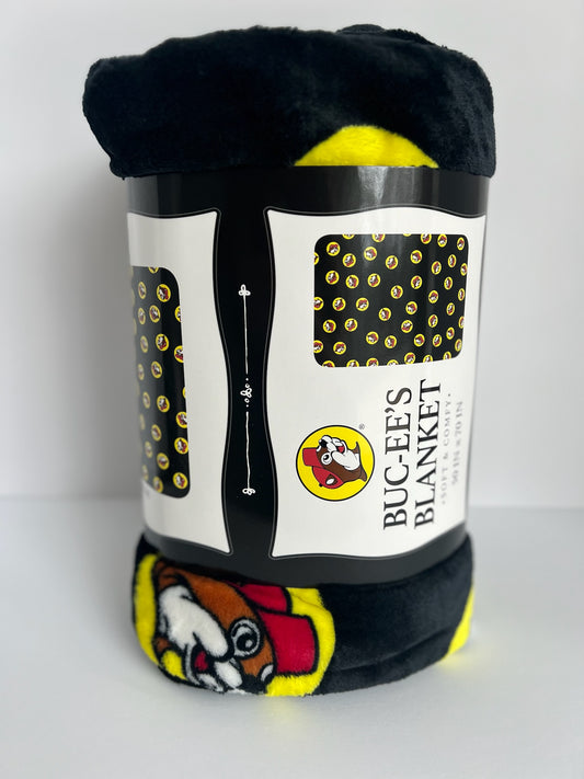 A black buc-ees' plush blanket rolled up and standing vertically